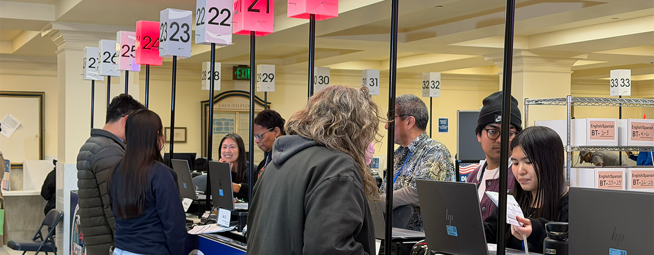 Election staff assisting voters to cast their votes