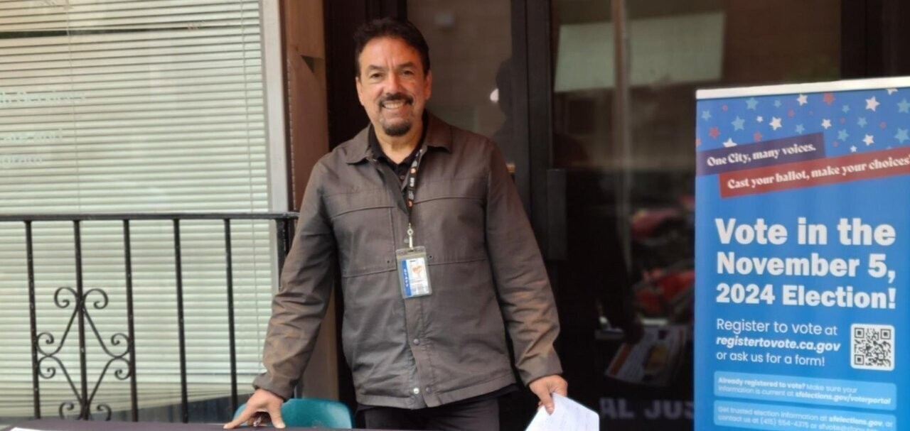 Photo of Erick Arguello of GLIDE hosting a resource table.