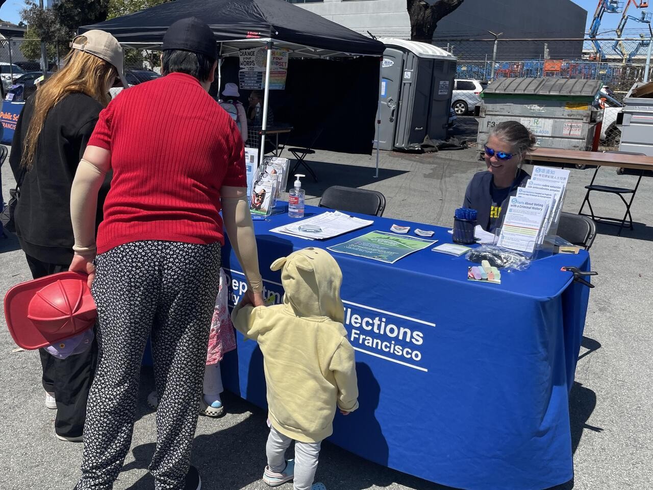 Photo of Elections staff conducting a resource table at a Back to School Celebration.