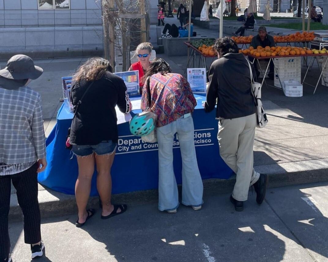 Four SF residents speaking with outreach staff about the upcoming election.