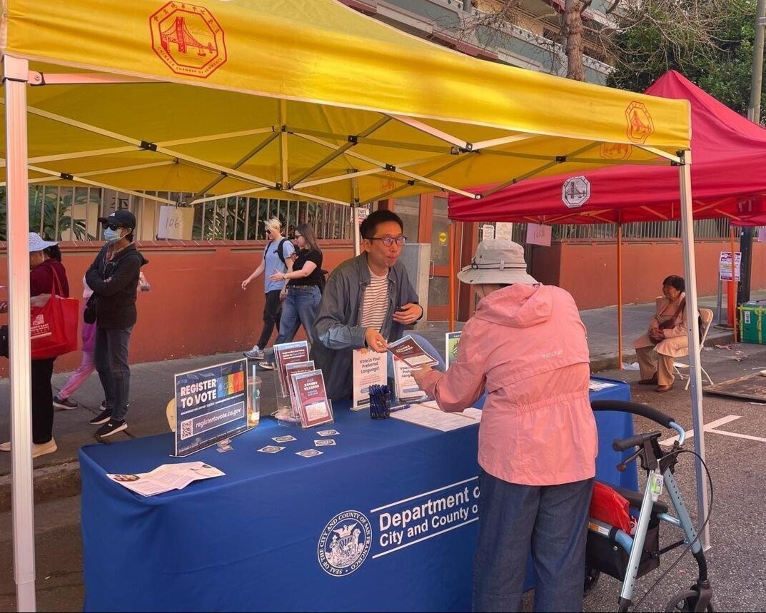 Elections staff handing an elderly SF resident a flyer about the NCV election.
