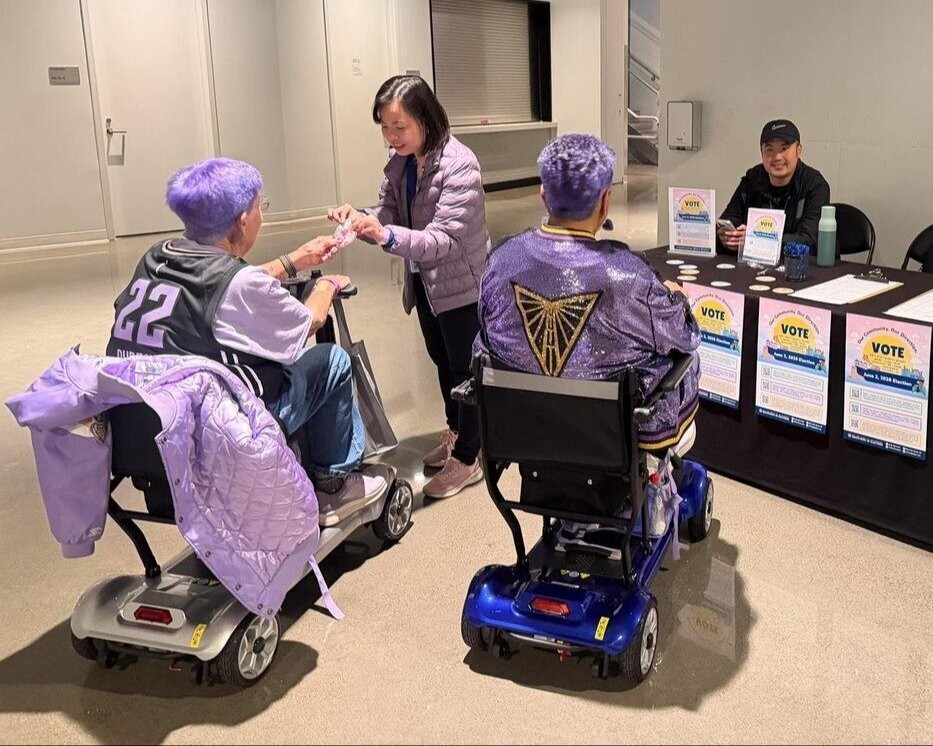 SF staff handing stickers to voters at the Chase Center