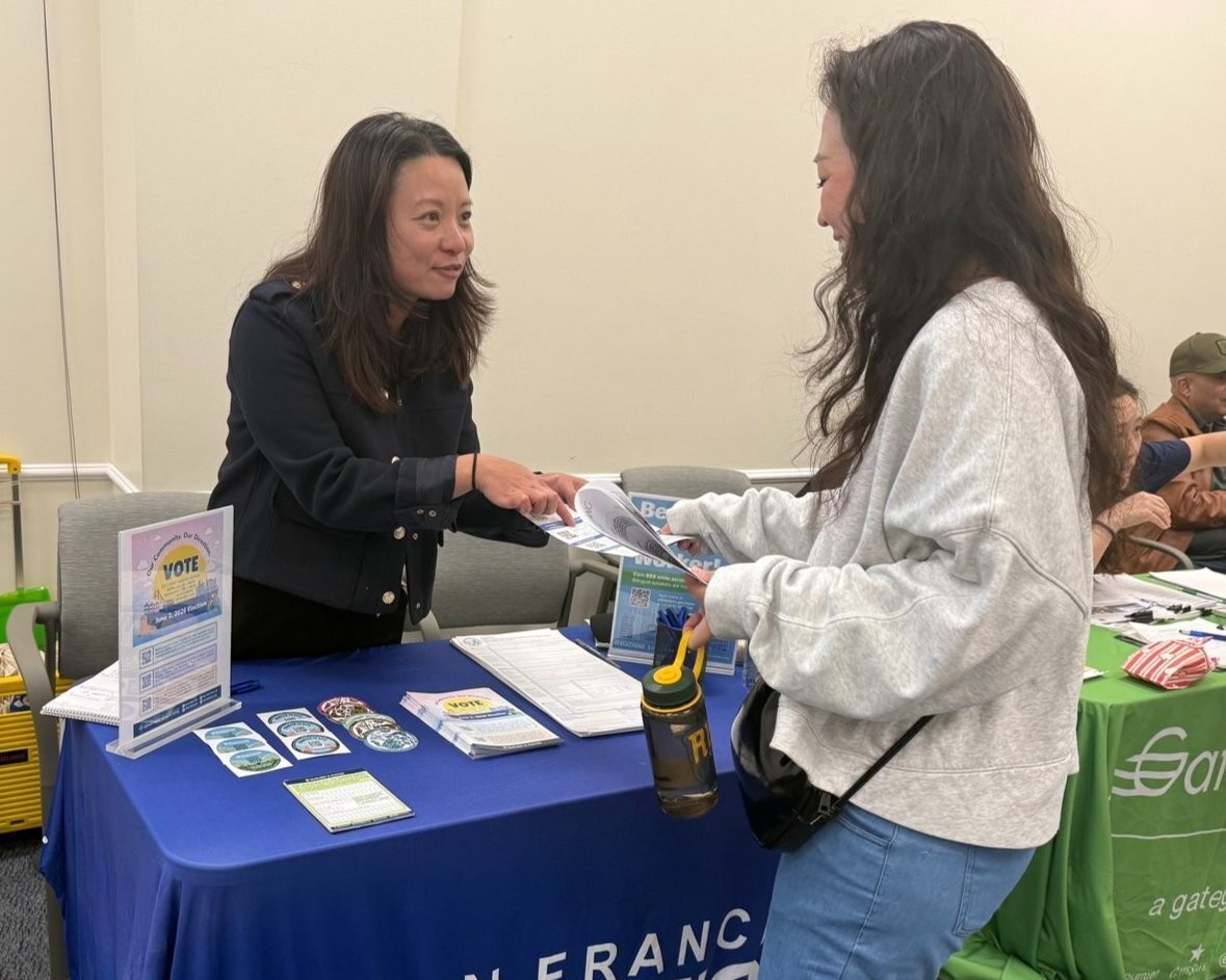 An Elections staff handing a flyer to a voter