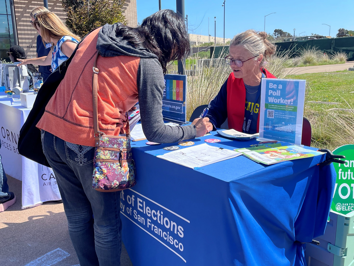 Department of Elections Staff assisting a voter at an outside event.