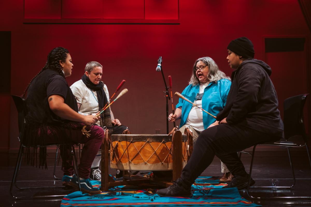4 people sitting around a musical instrument