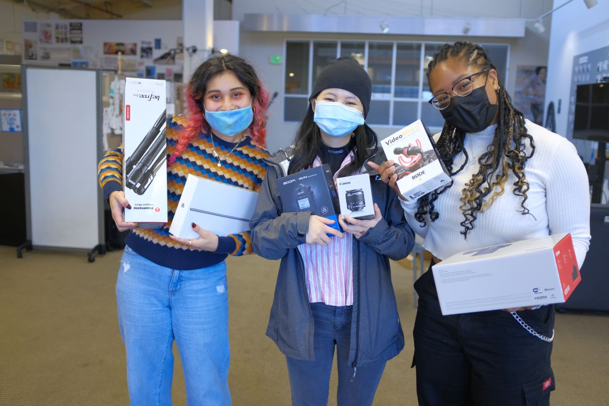 3 women in masks holding up tech prizes