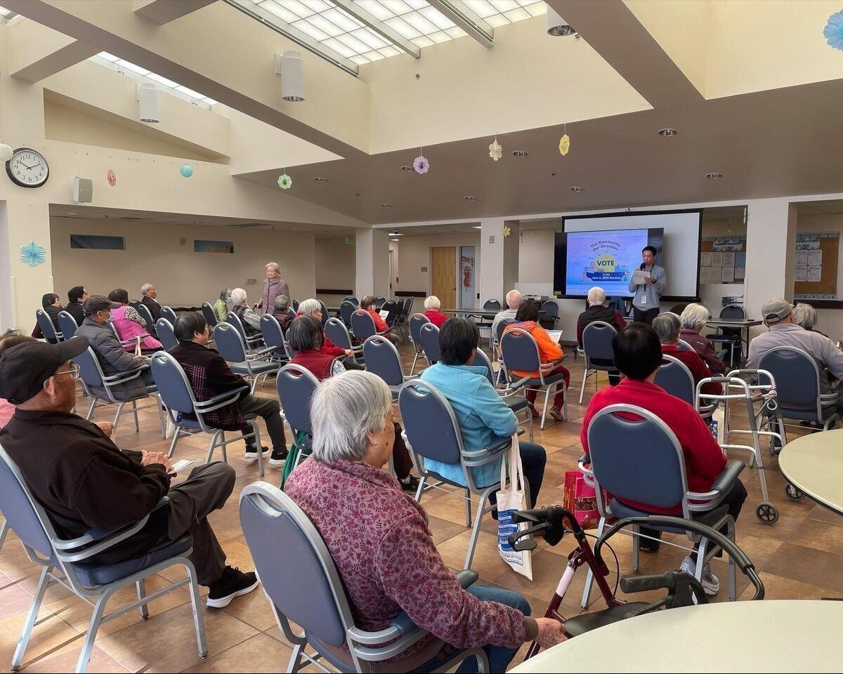 Department of Elections staff conducting a bilingual presentation to a gathering of Seniors.