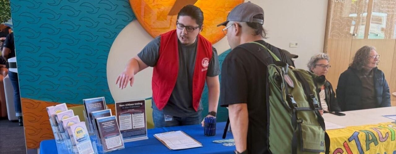 An SF Elections outreach member tabling and talking to an SF Resident