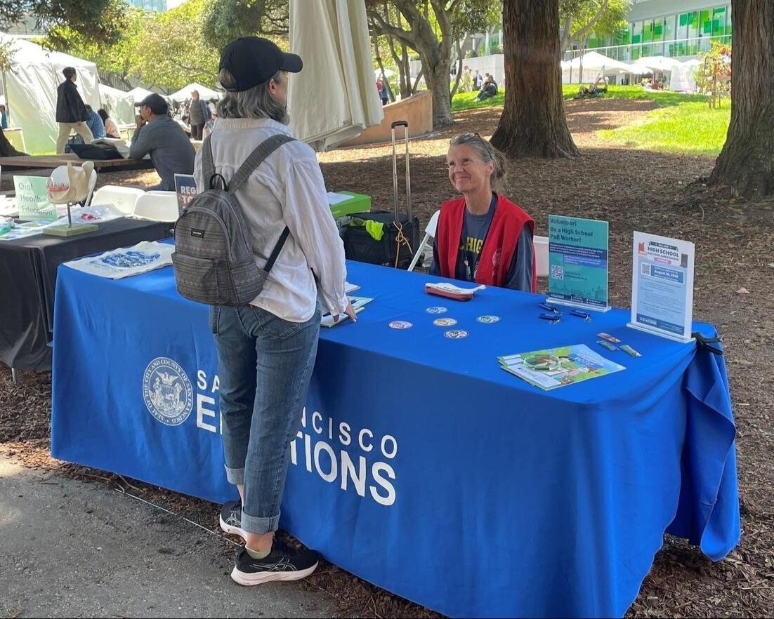 SF elections outreach member speaking with an SF resident at the Pistahan festival