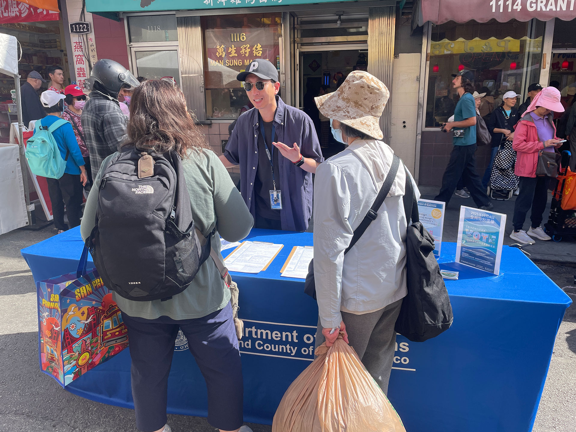 Elections staff sharing information with two SF residents at a Chinatown event.