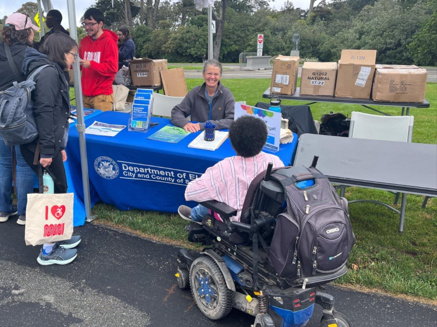 An Elections Outreach member speaking with an SF resident in a wheelchair.