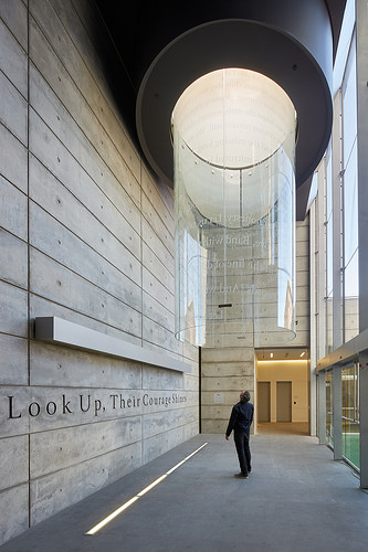 A contemplative memorial artwork uses light and structure to honor fallen officers, creating a reflective space that connects remembrance with the sky above.