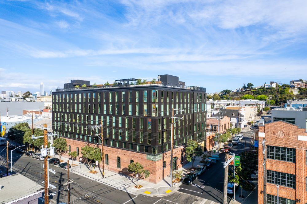 Grey building. Red brick on lower level and open rooftop