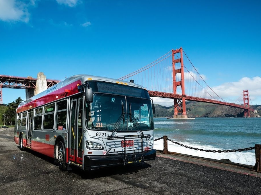 A Muni bus drives on the northern shoreline of San Francisco with the Golden Gate Bridge in the Background