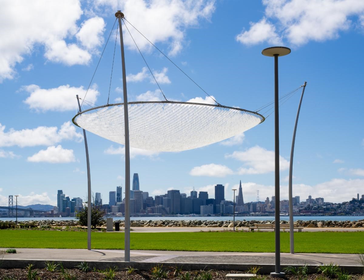 The sculpture Canopy of Sky by artist Ned Kahn is pictured in front of the San Francisco skyline