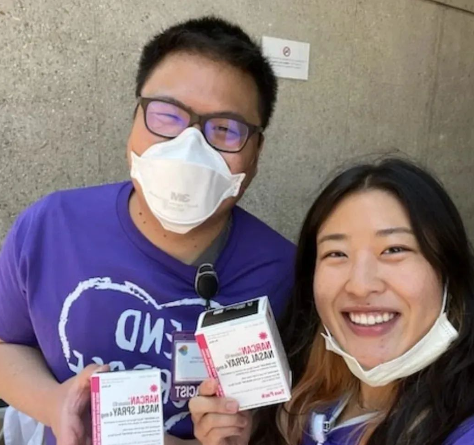 2 people holding naloxone boxes