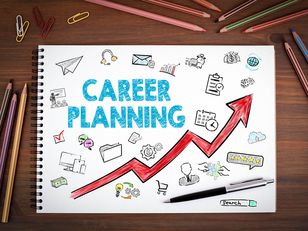 Career Planning. Notebooks, pen and colored pencils on a wooden table.