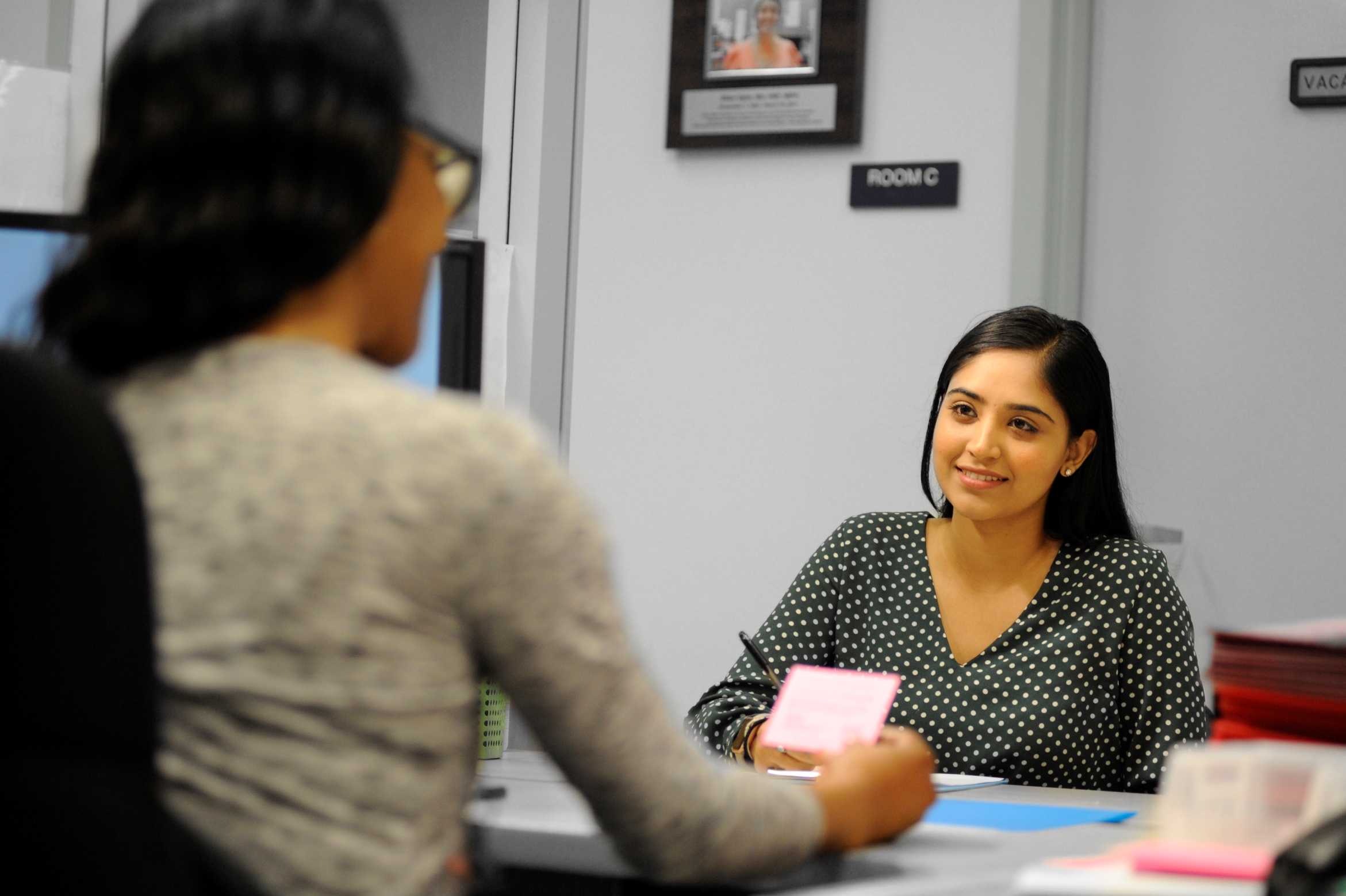 a staff person is interacting with a customer at a registration desk