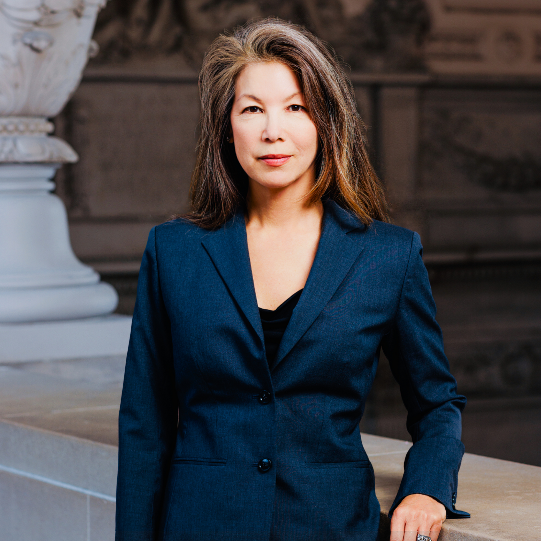 Woman with brown shoulder length hair wearing a black blazer