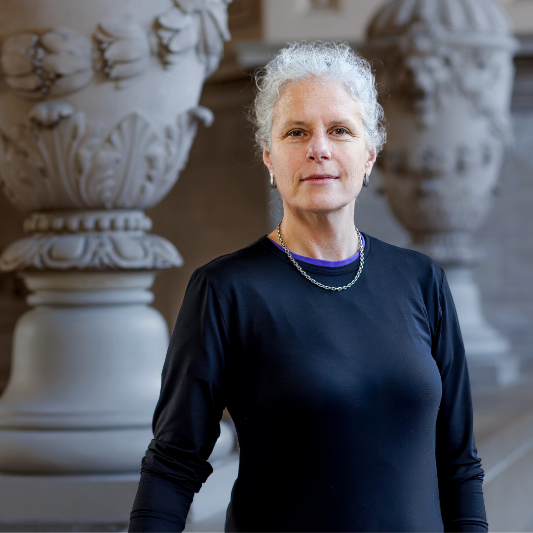 Woman with short white hair wearing a black shirt