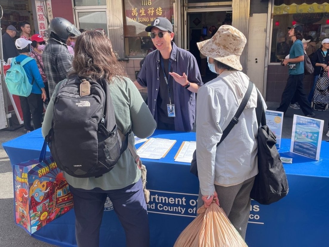 Elections staff speaking with two voters at an outreach event.
