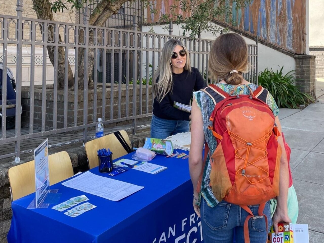 Elections staff smiling and speaking with an interested SF resident.