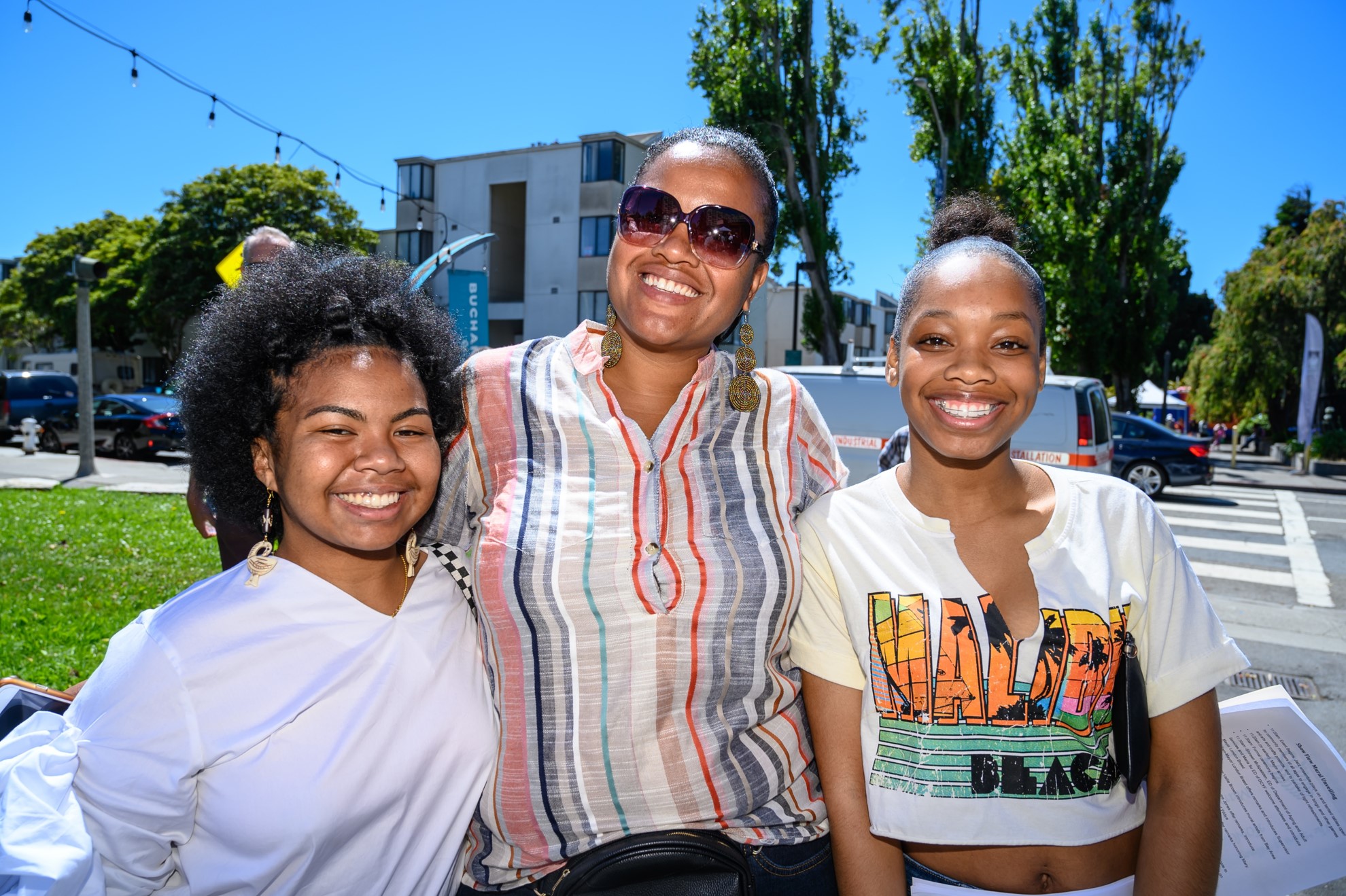 A mother and her 2 daughters at an outdoor event.