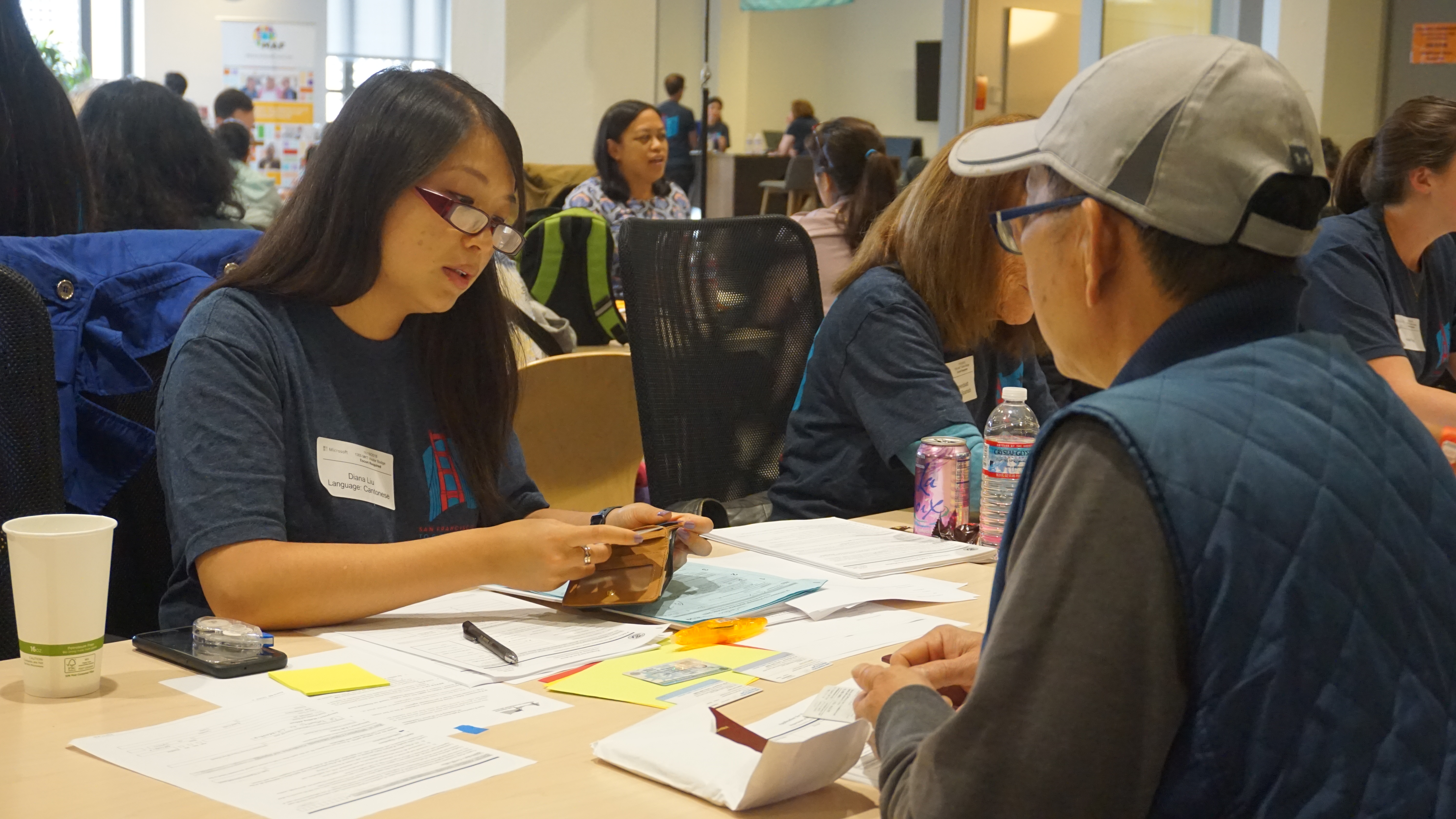 SF Pathways volunteer helps workshop participant fill out citizenship paperwork.