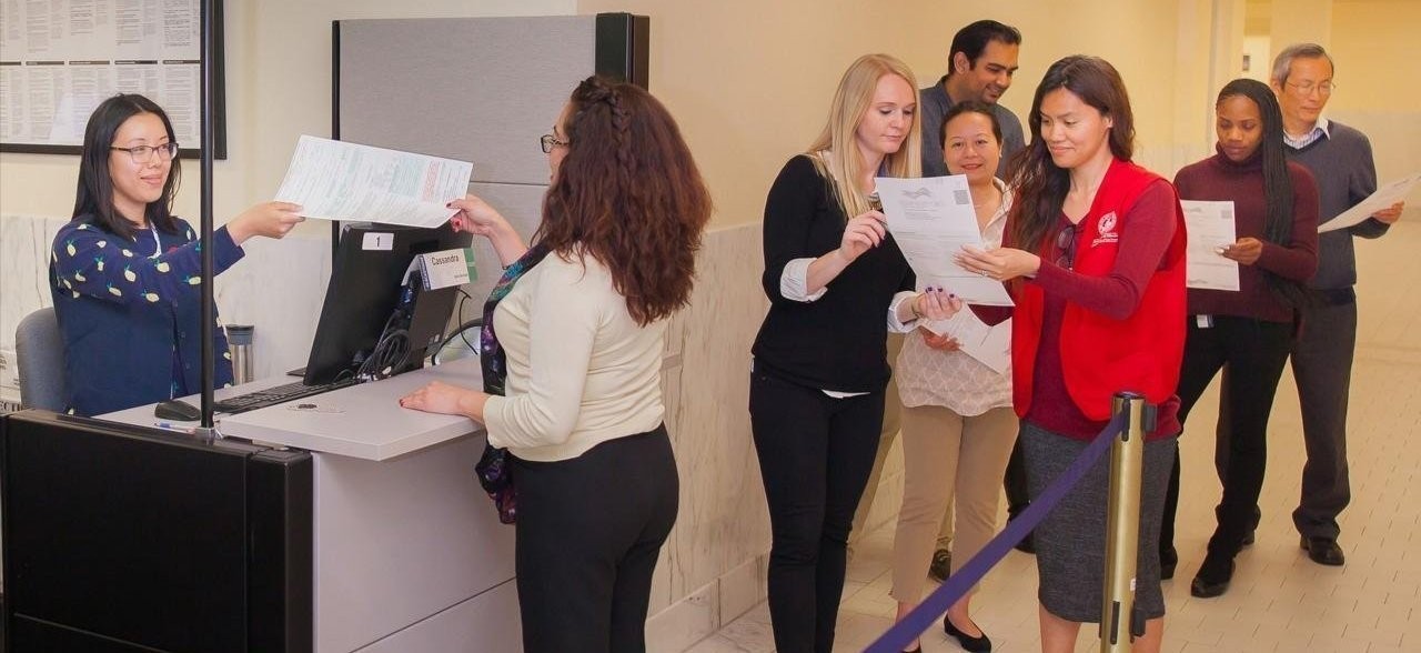 Two Elections staff members assisting a line of 6 SF residents.
