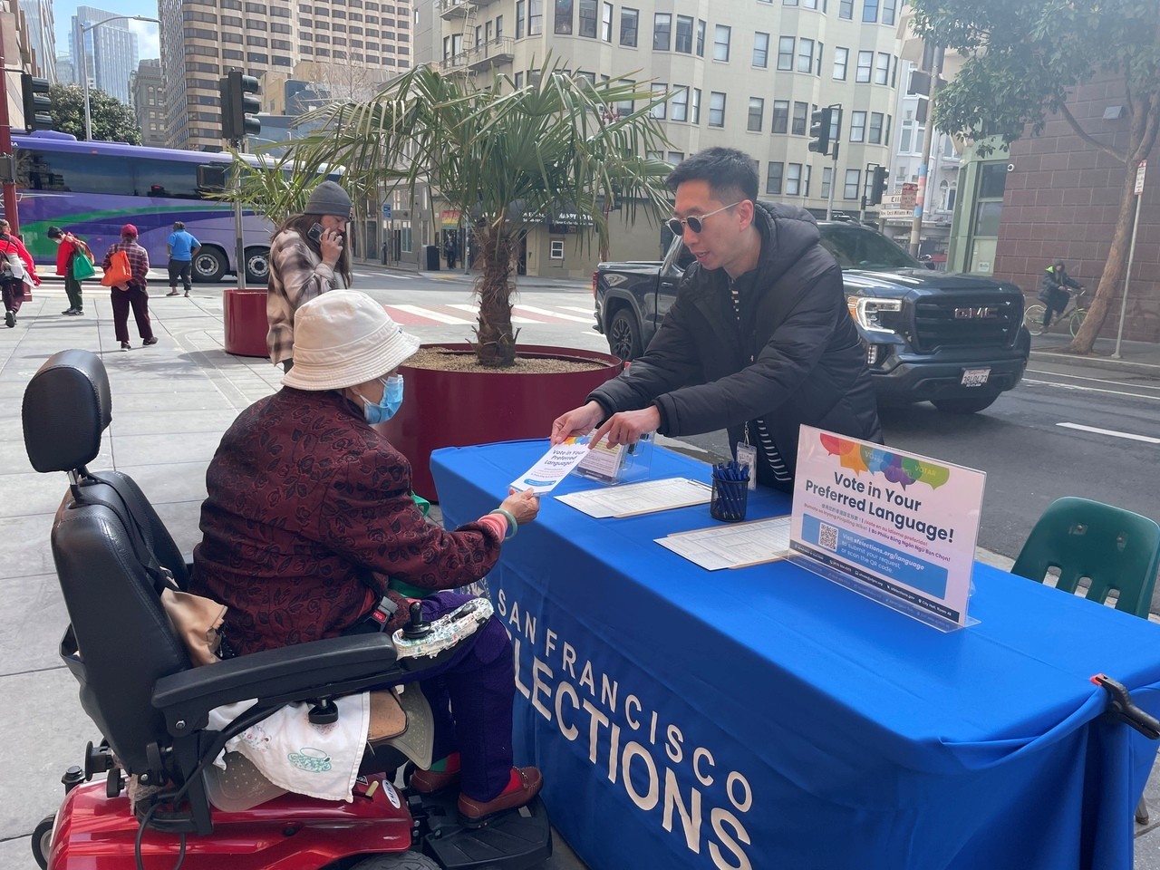 An SF resident receiving a flyer from an Elections Outreach staff member.