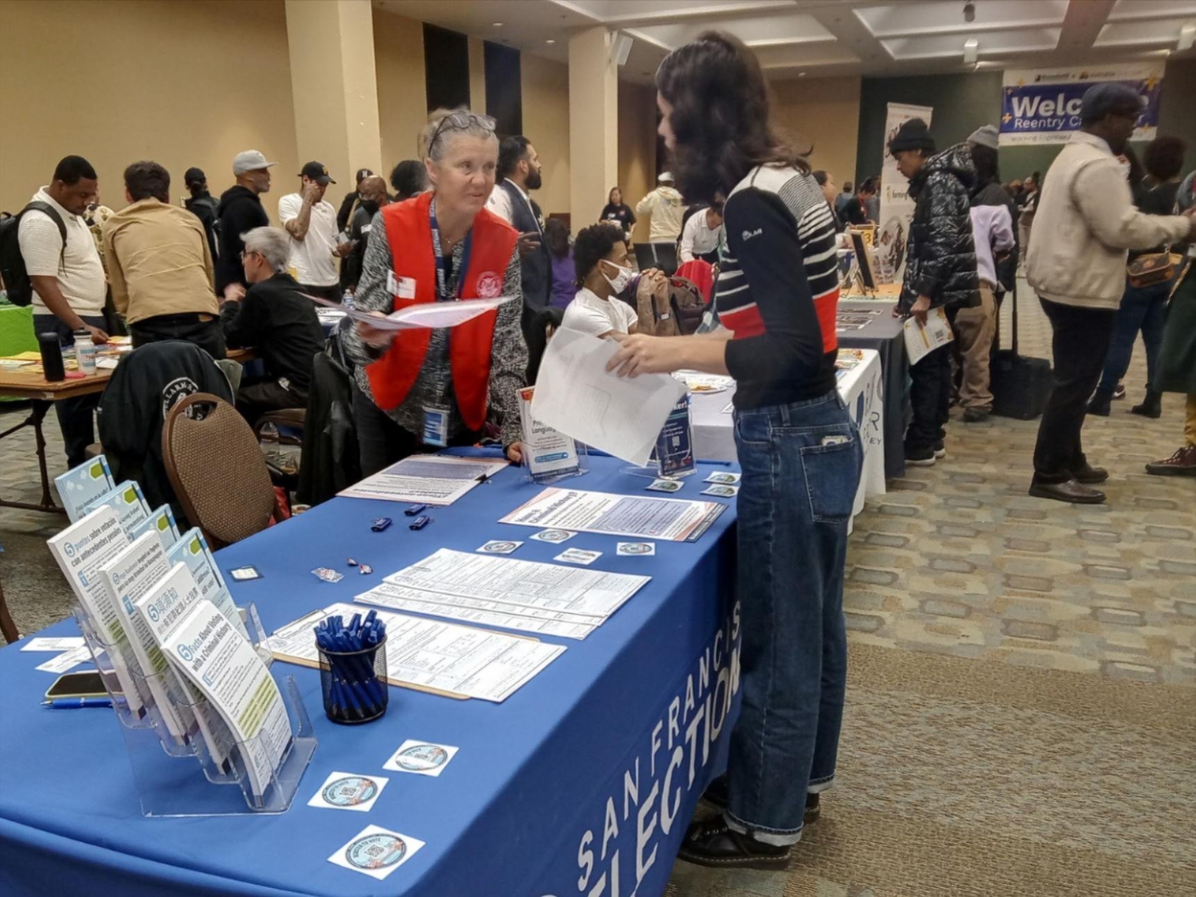 An Outreach member handing a flyer to an SF resident.
