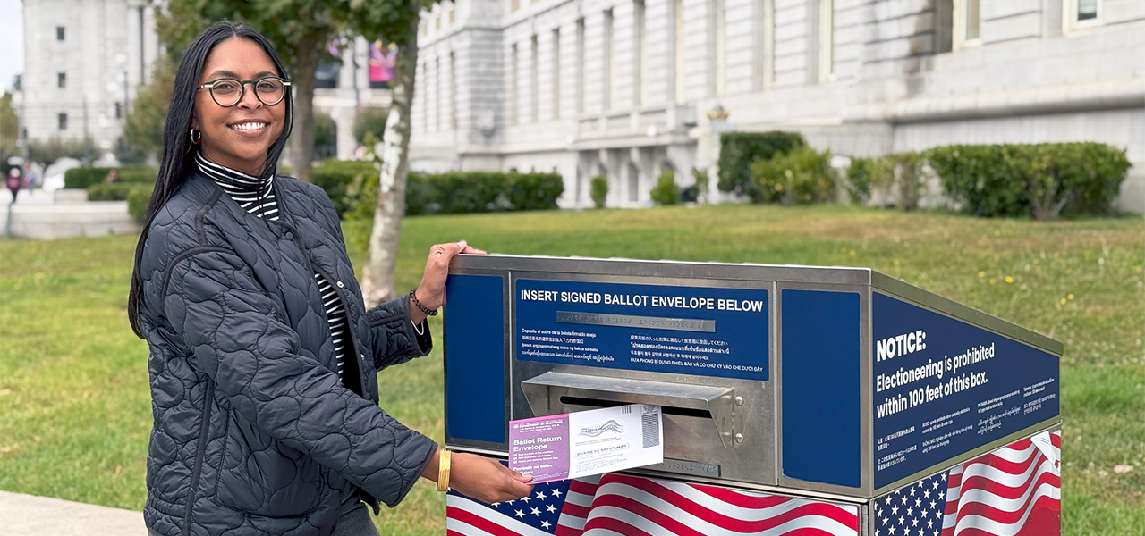 Picture of SF resident placing their mail-in-ballot into the drop box.