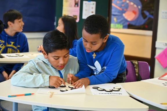Two boys working on schoolwork in a classroom