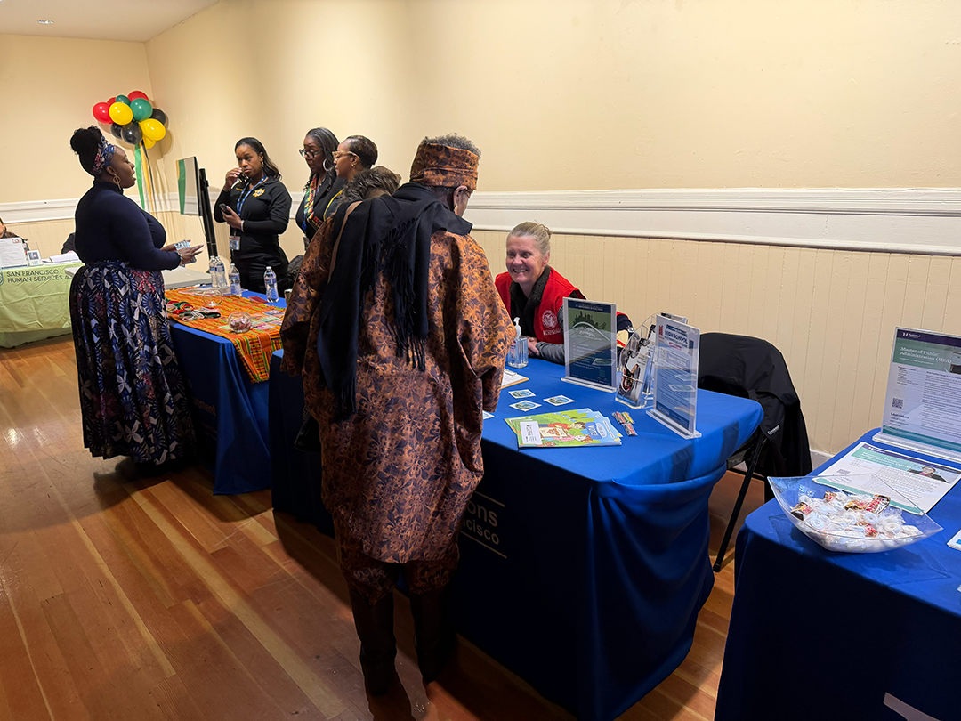 Picture of Elections Outreach staff speaking with a resident at the Black History Month Celebration.