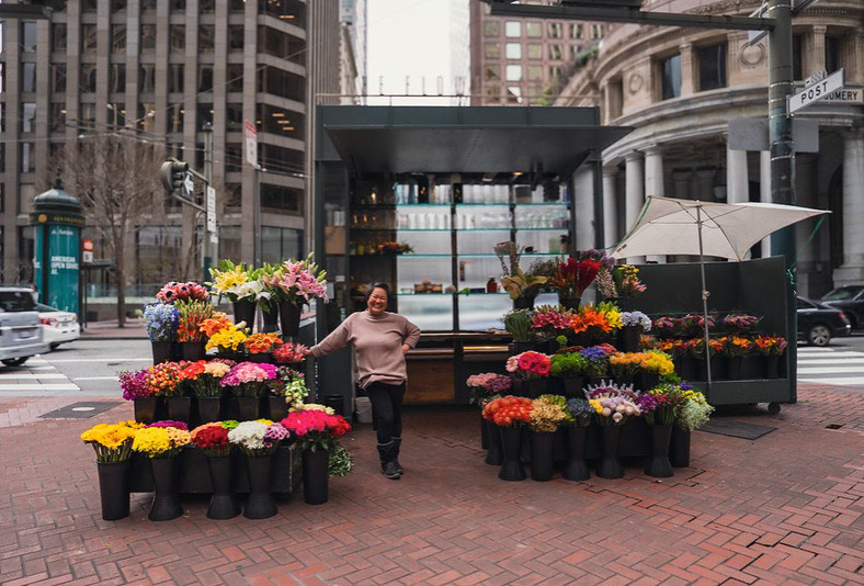 Flower stand with owner smiling