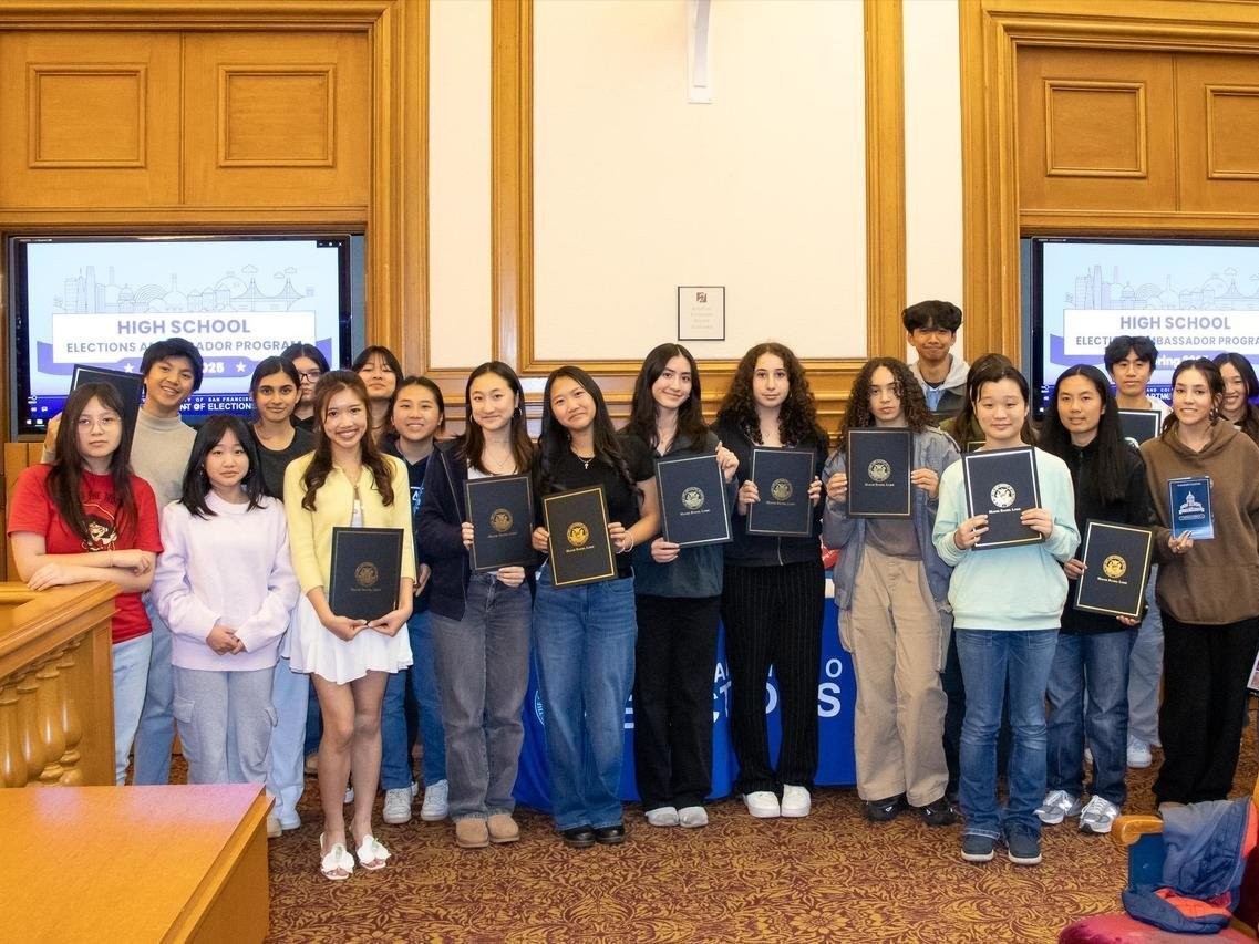A group photo of 15 High School Elections Ambassadors holding their certificates.