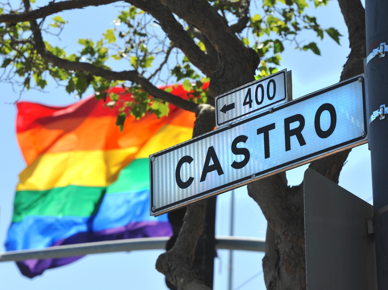 Pride flag waving behind the Castro street sign