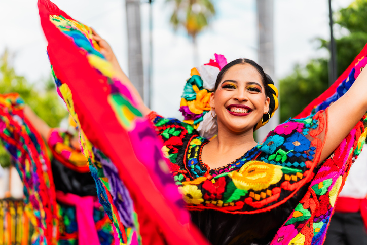 Young chiapaneca (traditional Mexican dancer) wearing vibrant, colorful dress dancing outdoors
