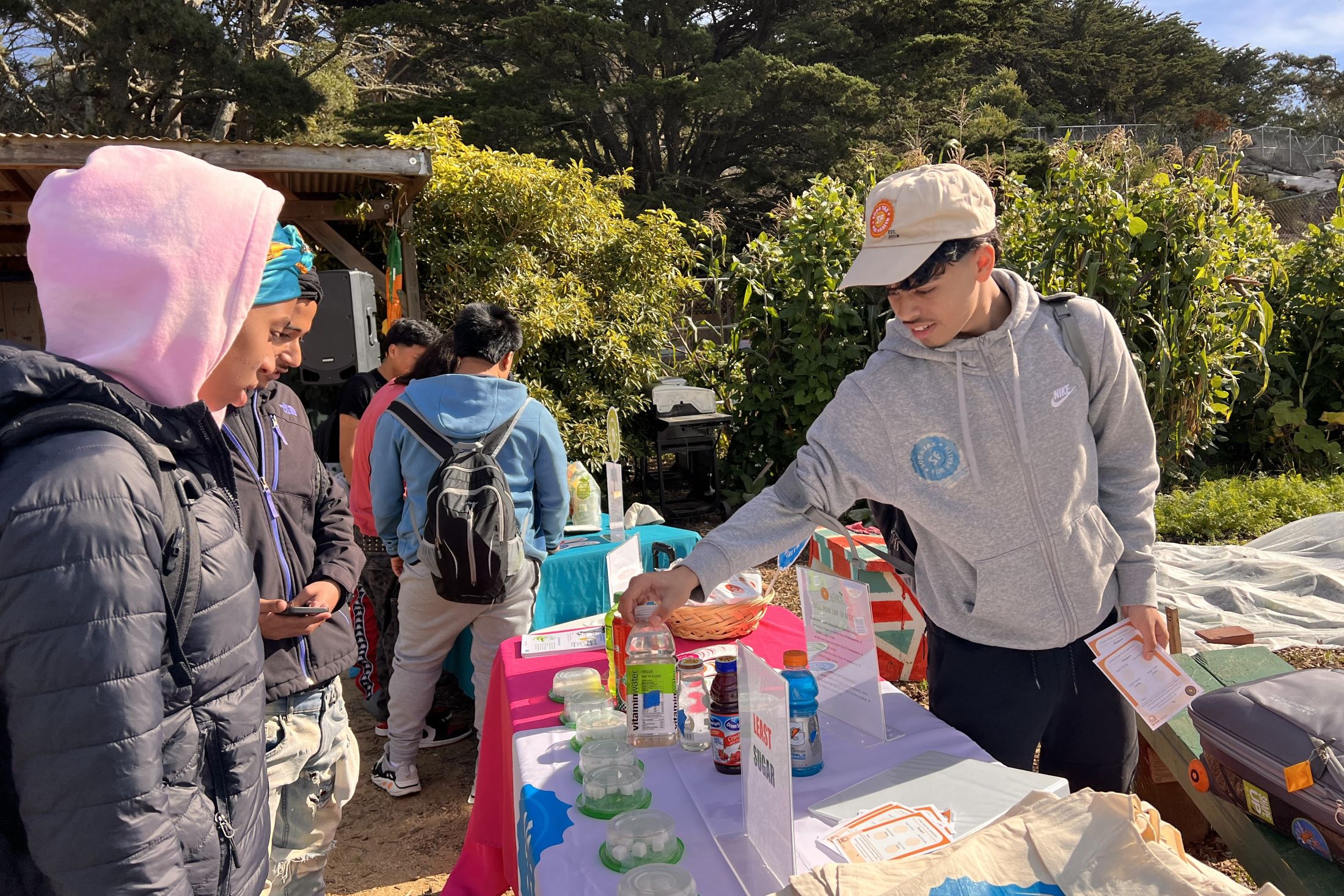 High school students guess how much sugar is in common sugary drinks displayed on a table