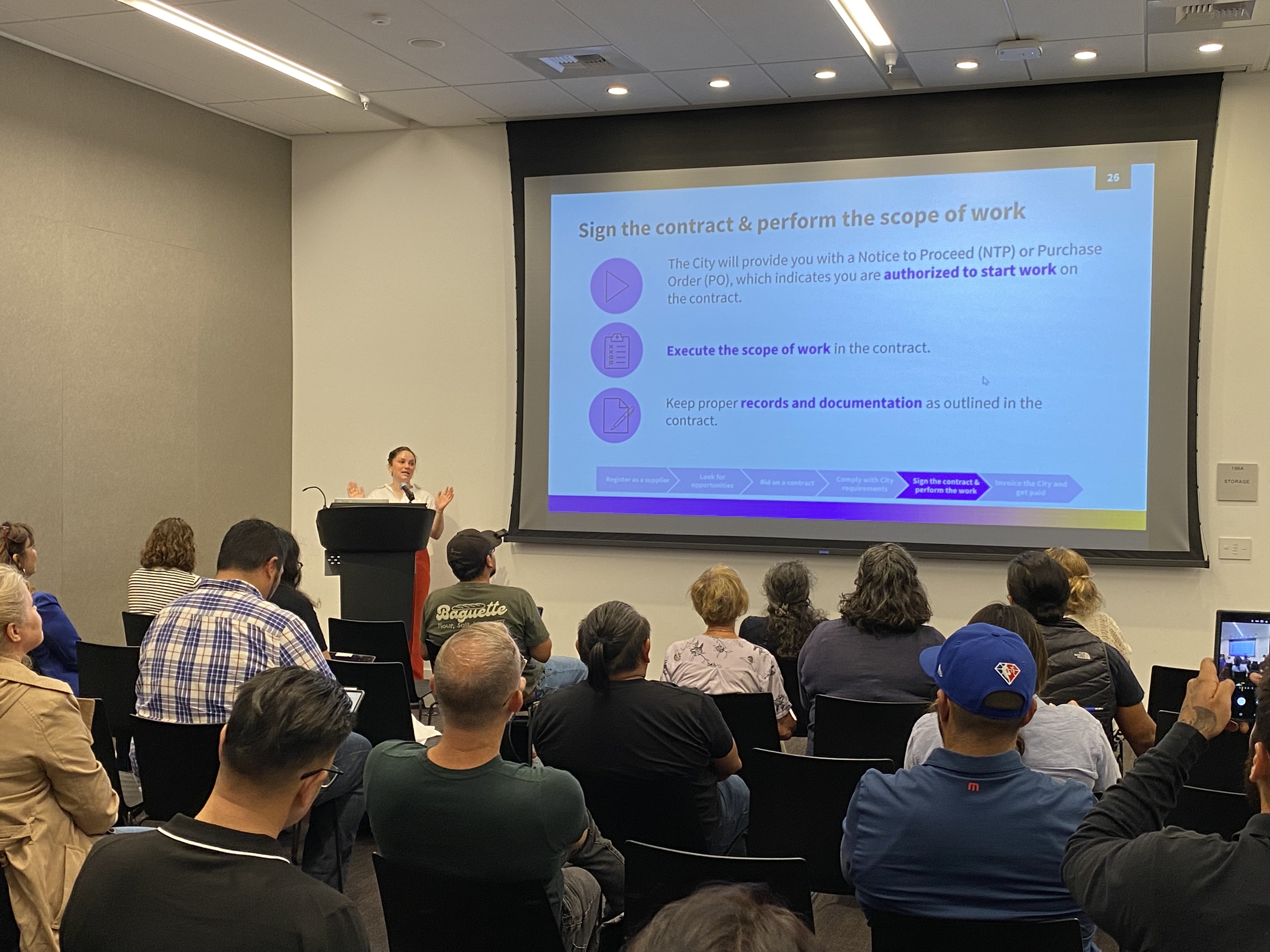 City staff presenting information about city contracting processes to a group of small business owners.