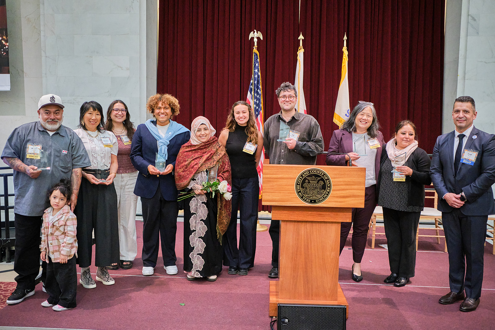 Immigrant Leadership Awards winners 2026 smile on stage at City Hall