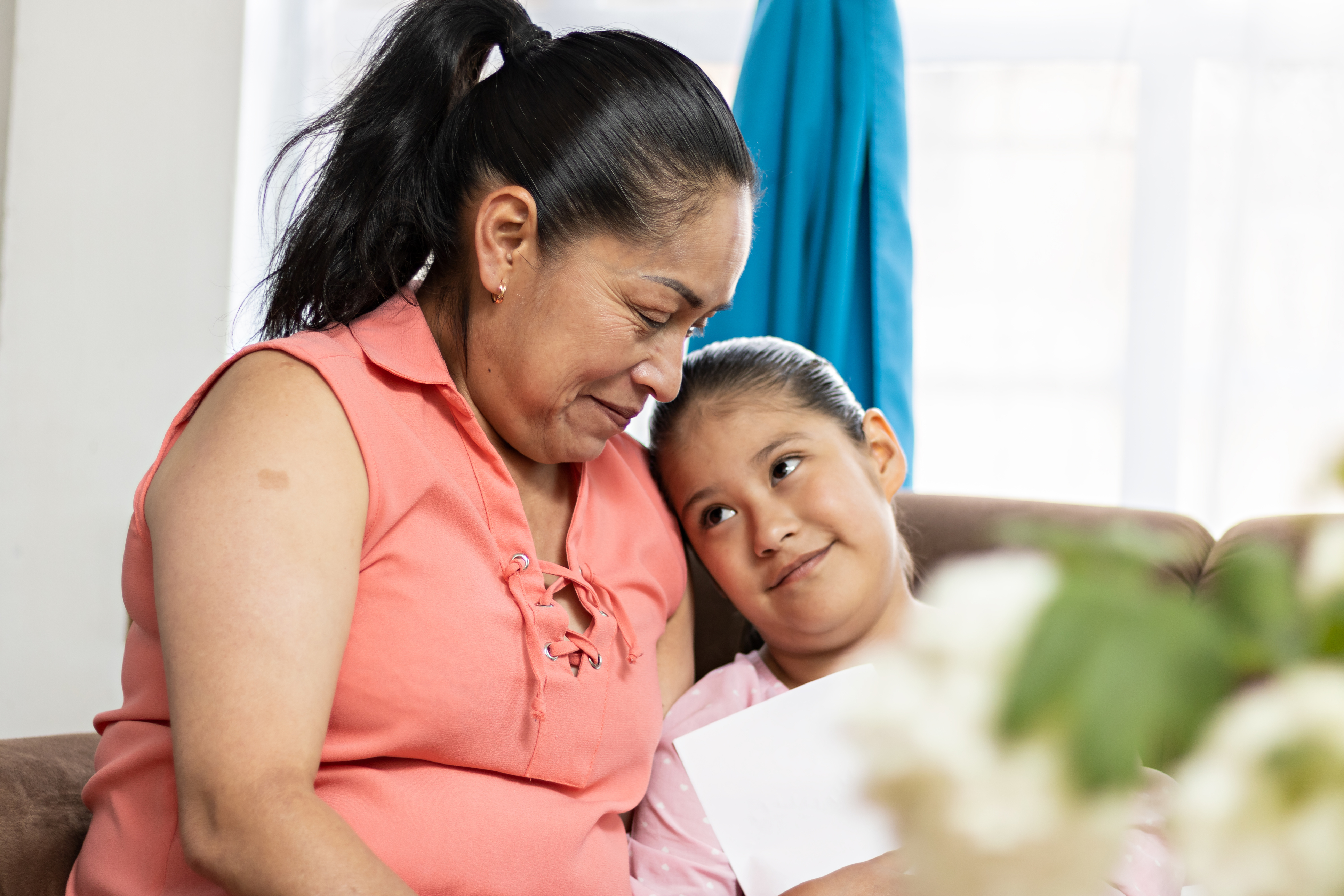 Mother smiling at her daughter while sitting on a couch
