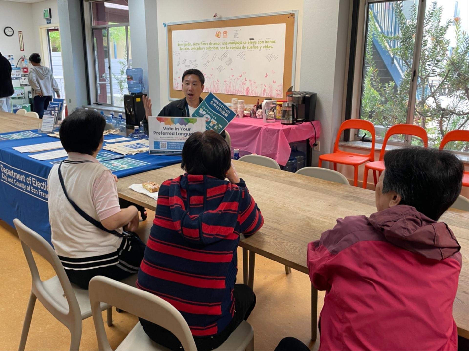 A bilingual Elections staff member speaking with 3 Chinese speaking SF residents.