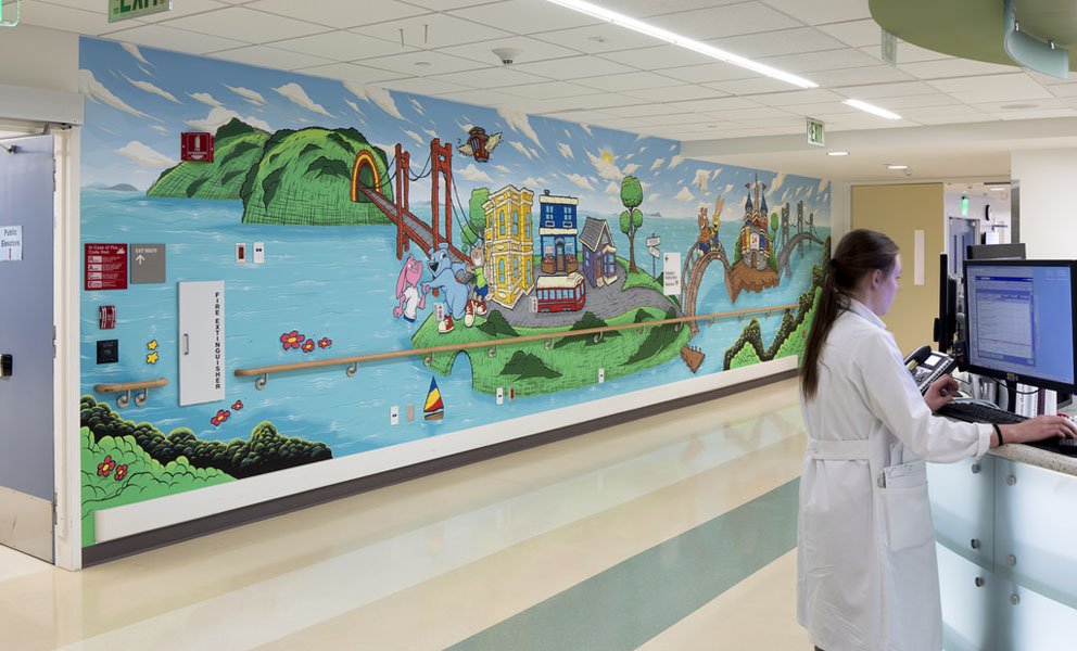 Colorful mural on an exterior hospital wall at San Francisco General Hospital, featuring large-scale painted figures and shapes.