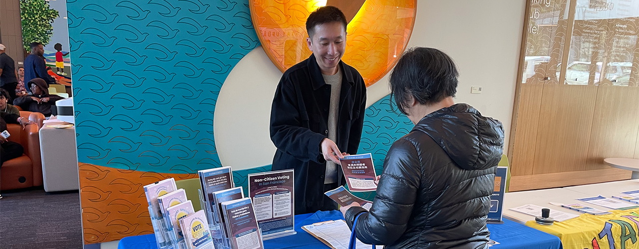 Department of Elections staff handing an NCV brochure to an SF resident.