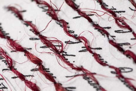 close-up of red stitched textile artwork.