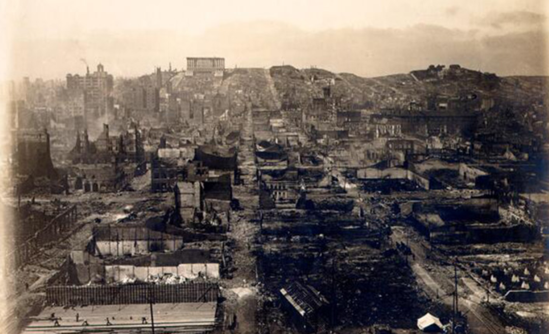 Historic black-and-white photo showing widespread urban destruction, with ruins and damaged buildings stretching across a city landscape.
