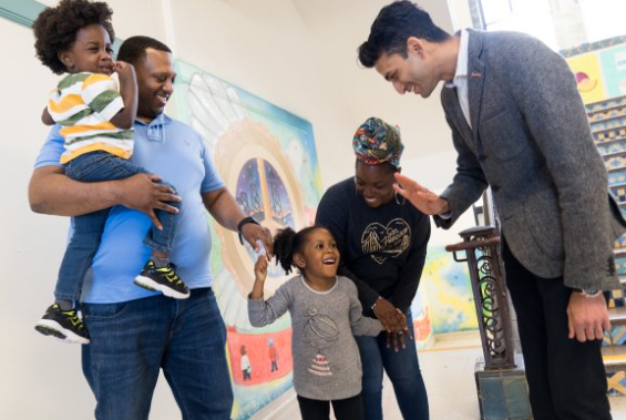 family with a child giving a school principal a high five
