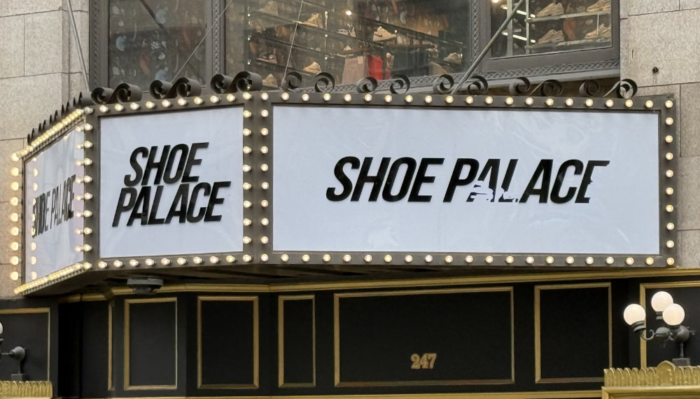 A permanent triangular marquee over an entrance of a storefront, showing no supporting columns.