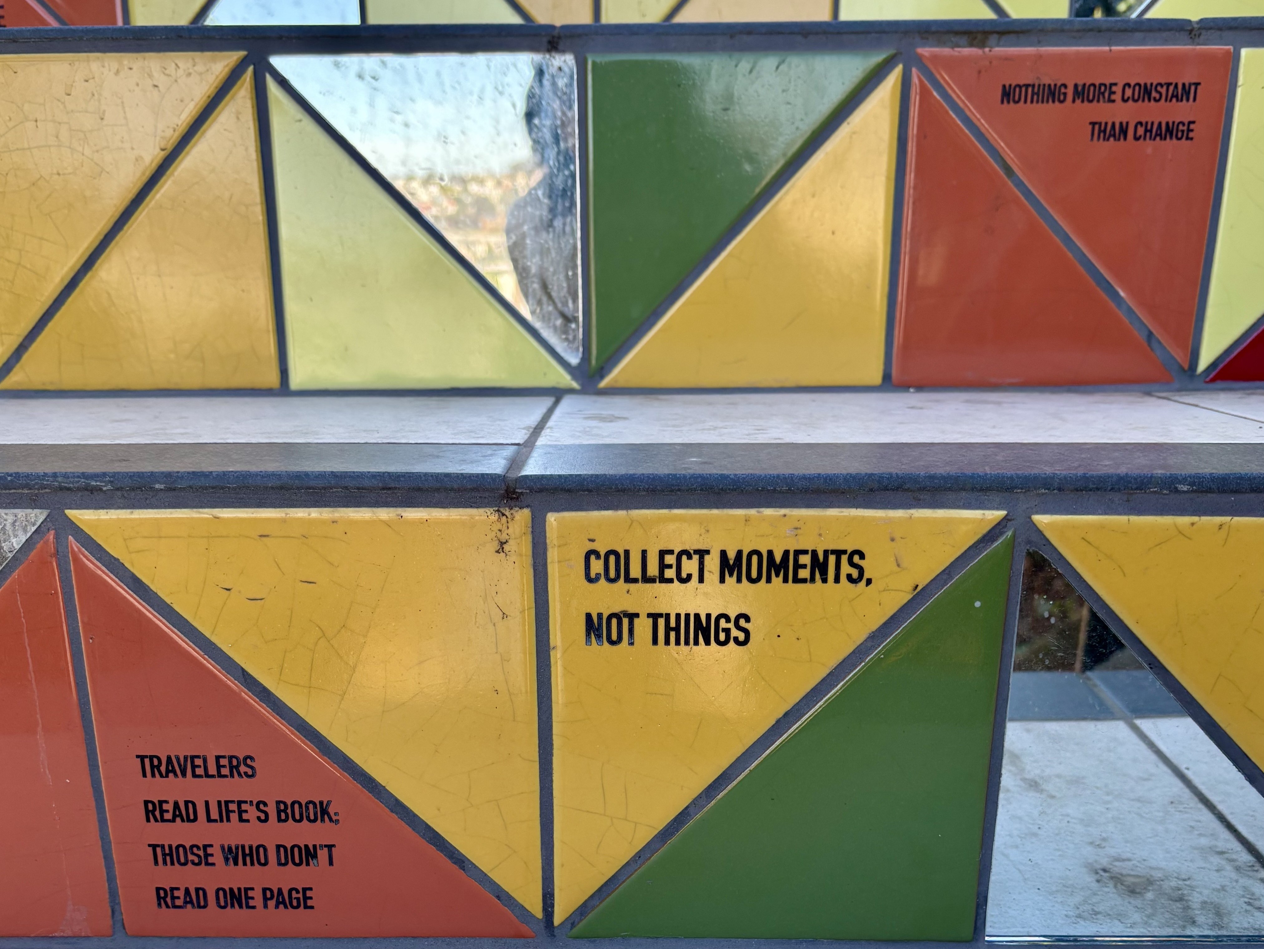 Close up of a tiled staircase made of half-square triangles. Some tiles are mirrored. Some are in red, green, or yellow.